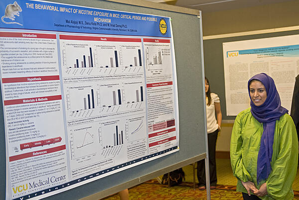 Mai Alajaji, a student in the VCU Department of Pharmacology and Toxicology, stands by her display, which addresses nicotine exposure, at VCU’s Virginia Youth Tobacco Projects Research Conference.