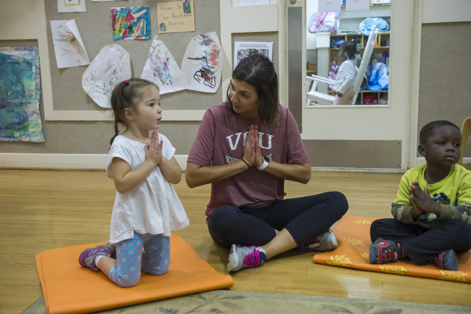 Medical student Celeste Pilato works with a child during yoga class. 