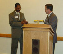 New Staff Senate President Mark Divens (left) accepts the gavel of leadership from outgoing Staff Senate President Grant Warren as the first order of business.

Photo by Jane Lalich, Staff Senate