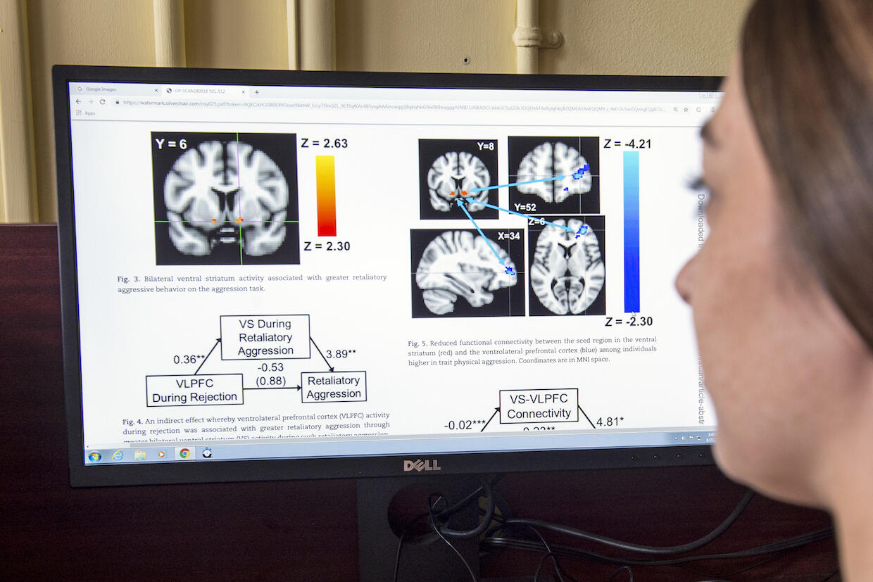 A student views brain scan imagining and analysis on a computer screen.