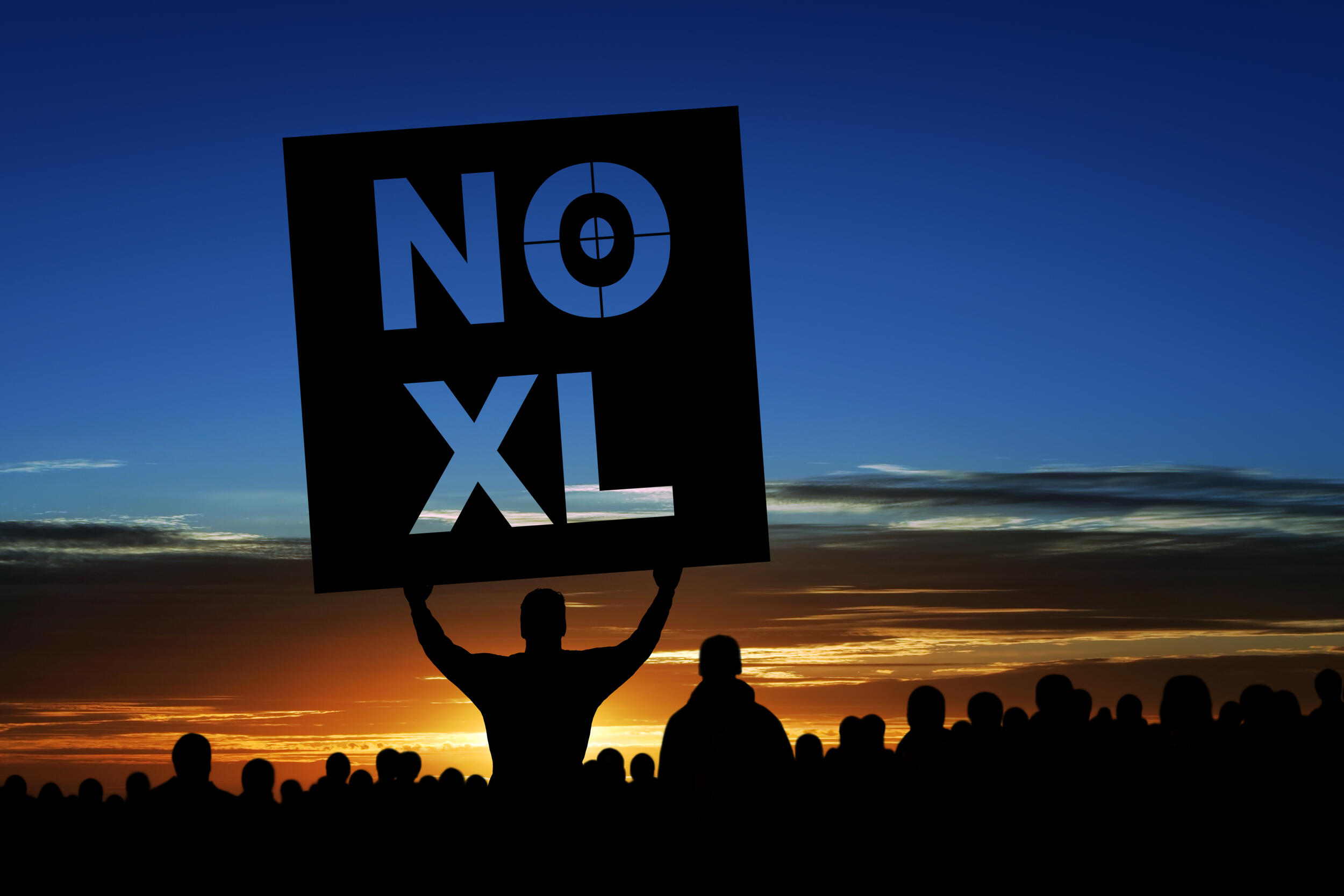 The silhouette of a person holding a sign that says \"NO XL\"