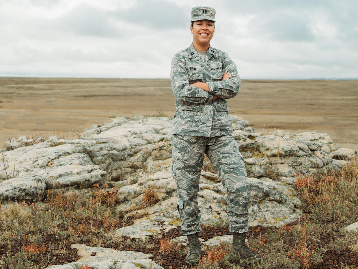 Woman in Army camouflage standing.