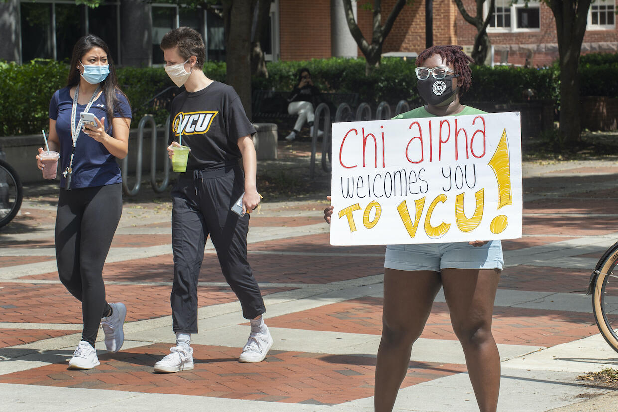 A VCU student holds a welcome sign on the first day of classes on Aug. 17.