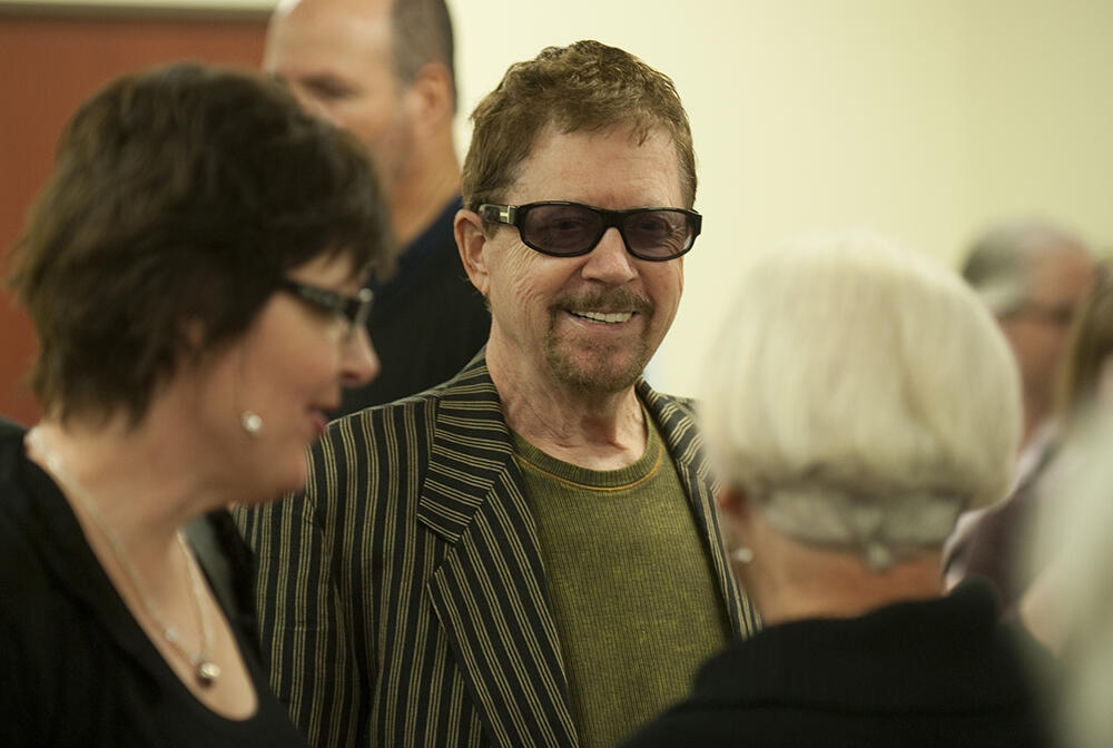 A photo of a man wearing sunglasses in a crowd of people. 