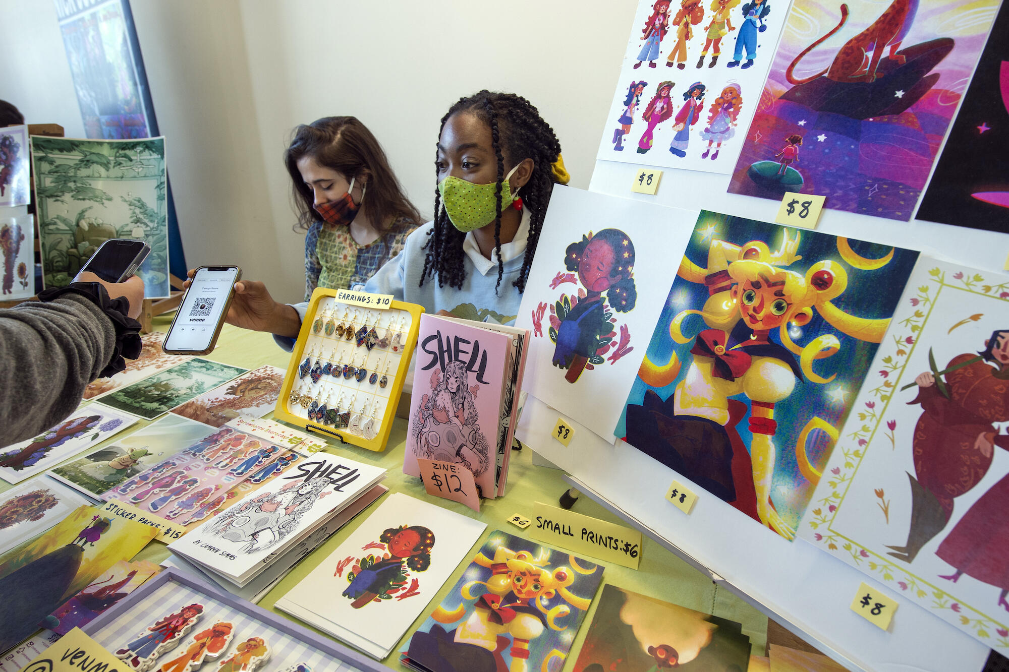 VCU graduates Camryn Simms (right) and Lillian Trenton display and sell their artwork at the Richmond Indie Comic Expo.