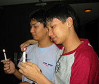 From left: VCU students and brothers Tin Htut Myint and Myo Thwin Myint take a moment to reflect with one another during the silent candlelight vigil for hope.