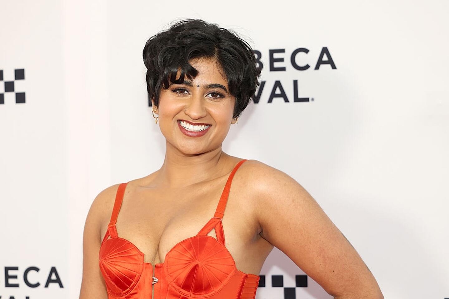 A photo of a woman from the chest up. She is smiling. 