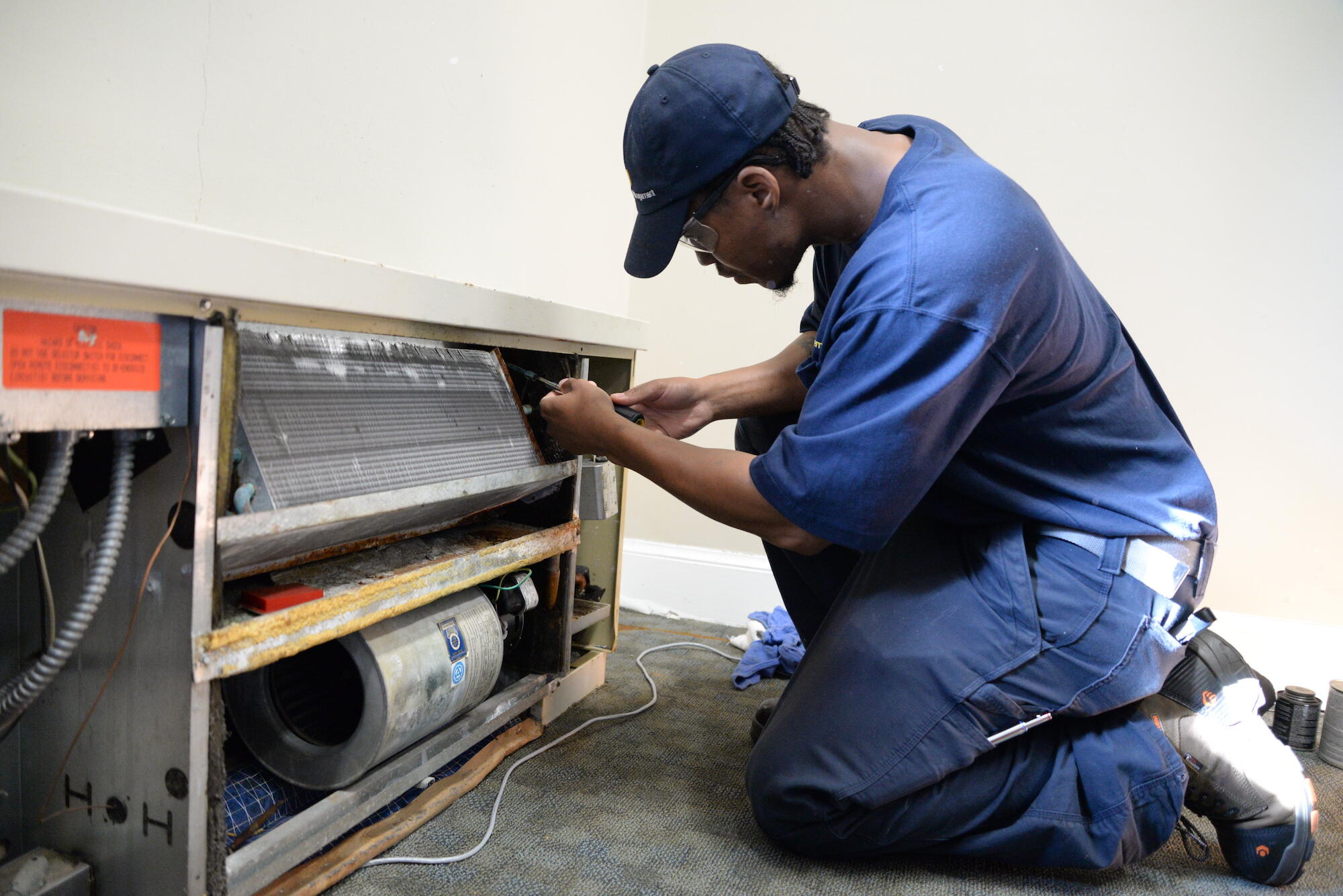 Jonathan Jones fixing a malfunctioning fan cooling unit