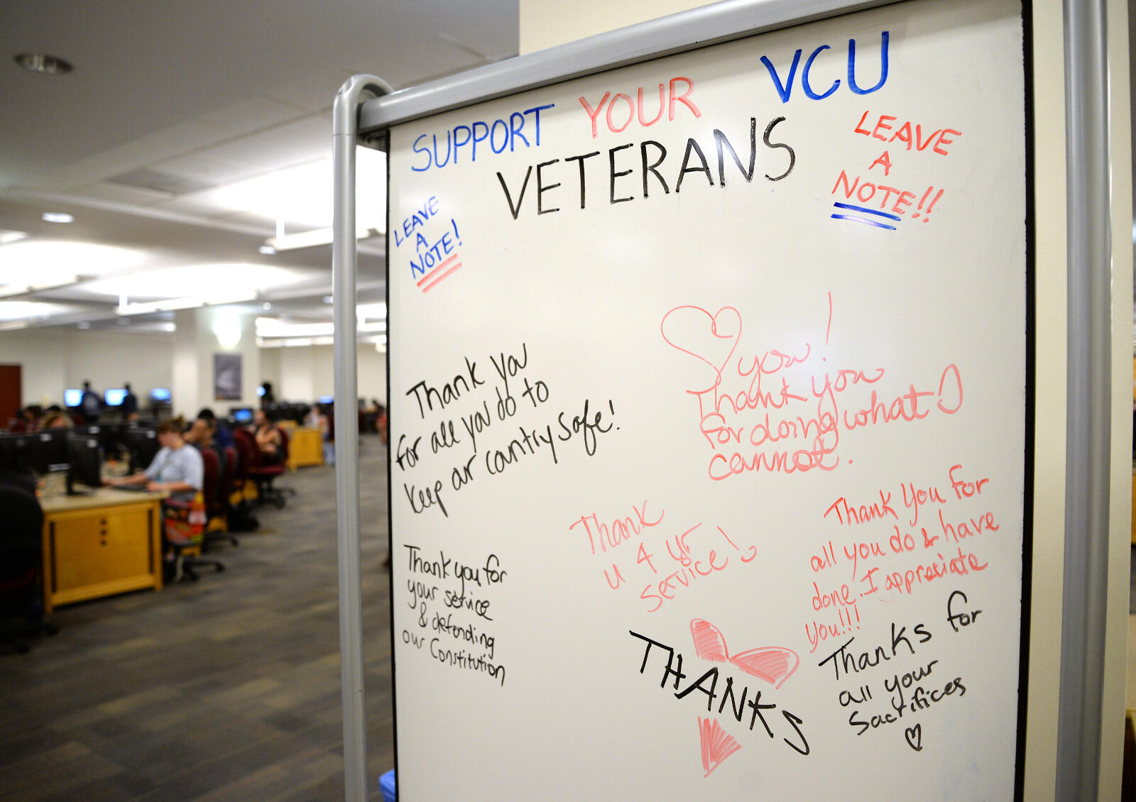 A whiteboard nearby invites VCU community members to write notes of thanks to veterans.