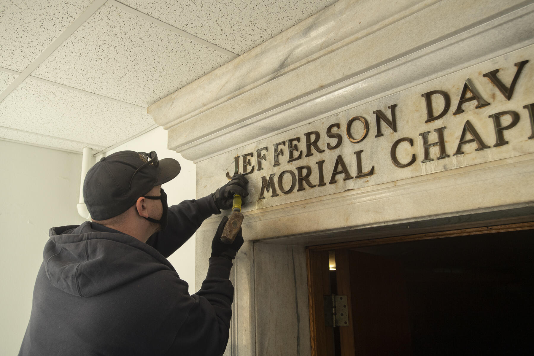 A V C U worker removes letters from the Jefferson Davis Memorial Chapel in the West Hospital.