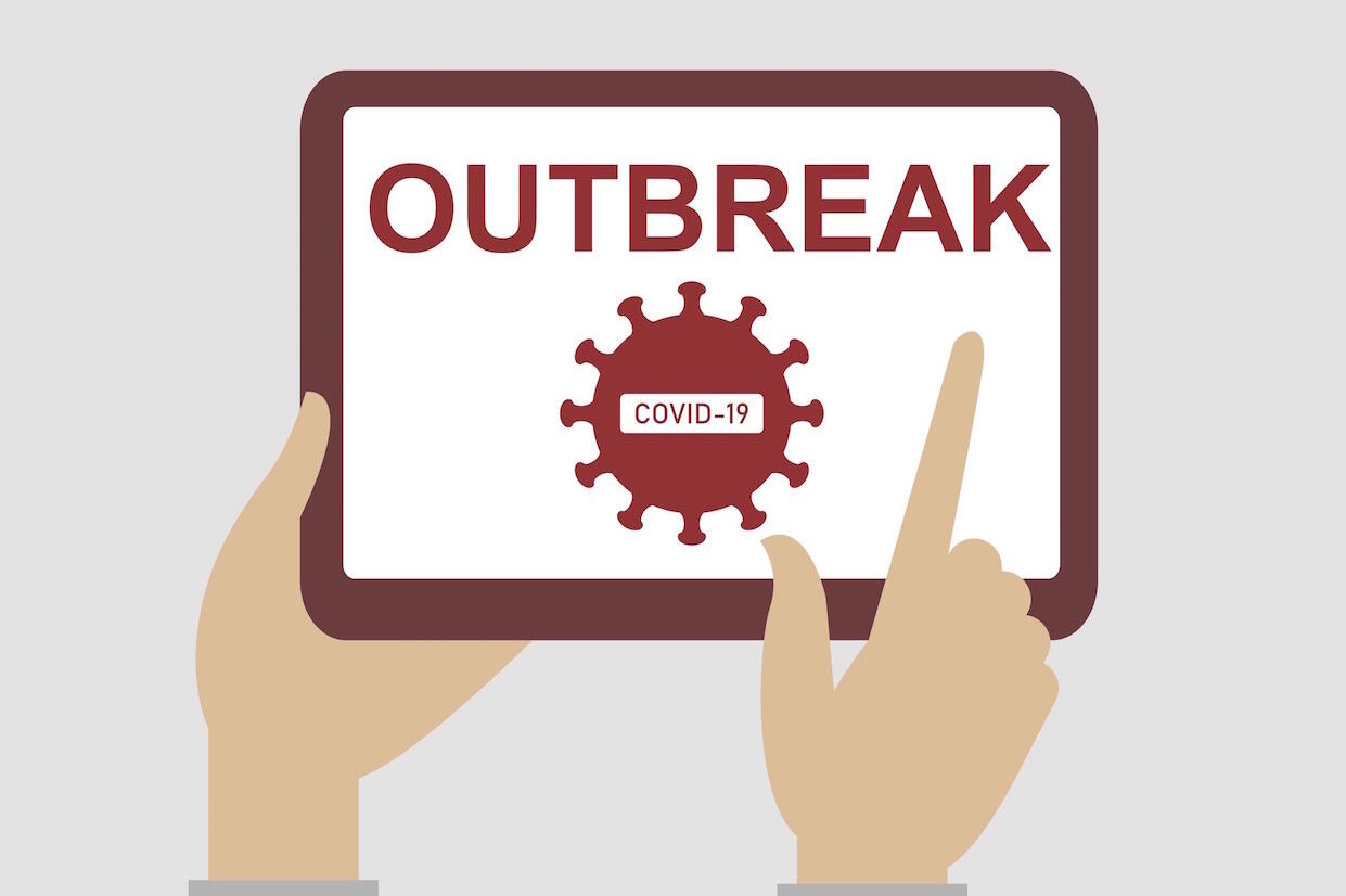 A person holds a digital tablet that displays the word \"outbreak\" and a depiction of the COVID-19 virus.