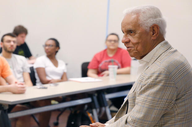 L. Douglas Wilder speaking to students inside a classroom.