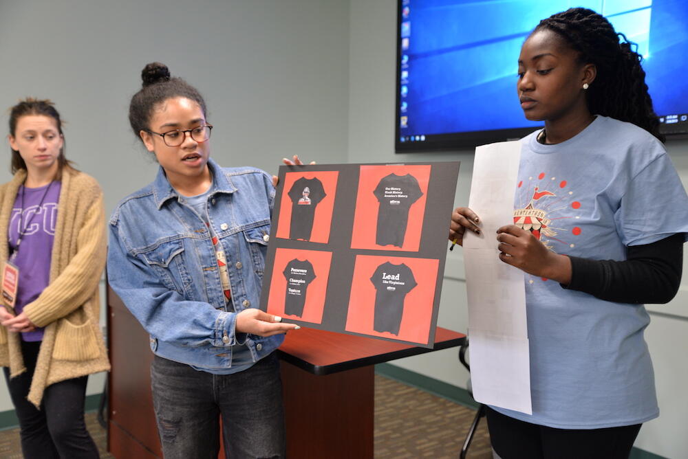 Ciara Reed, a senior creative and strategic advertising major, shows Andrea Wright of the Black History Museum and Cultural Center t-shirt designs created by her team. (Photo by Brian McNeill, University Public Affairs)