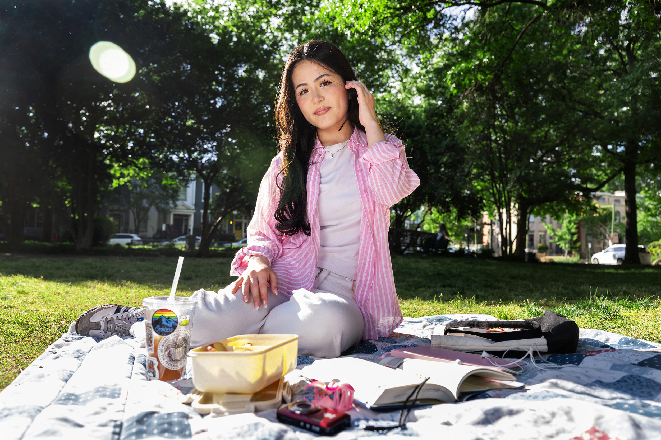 A photo of a woman outside sitting and having a picnic. 