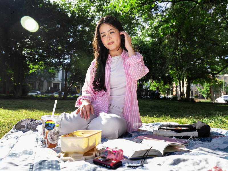 A photo of a woman outside sitting and having a picnic. 