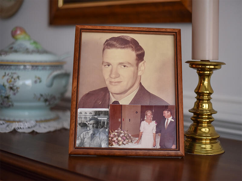 A framped photo of a man with two other photos stuck in it. On the left at the bottom is a photo of a man sitting. On the the right is a photo of a man and woman in wedding clothes.
