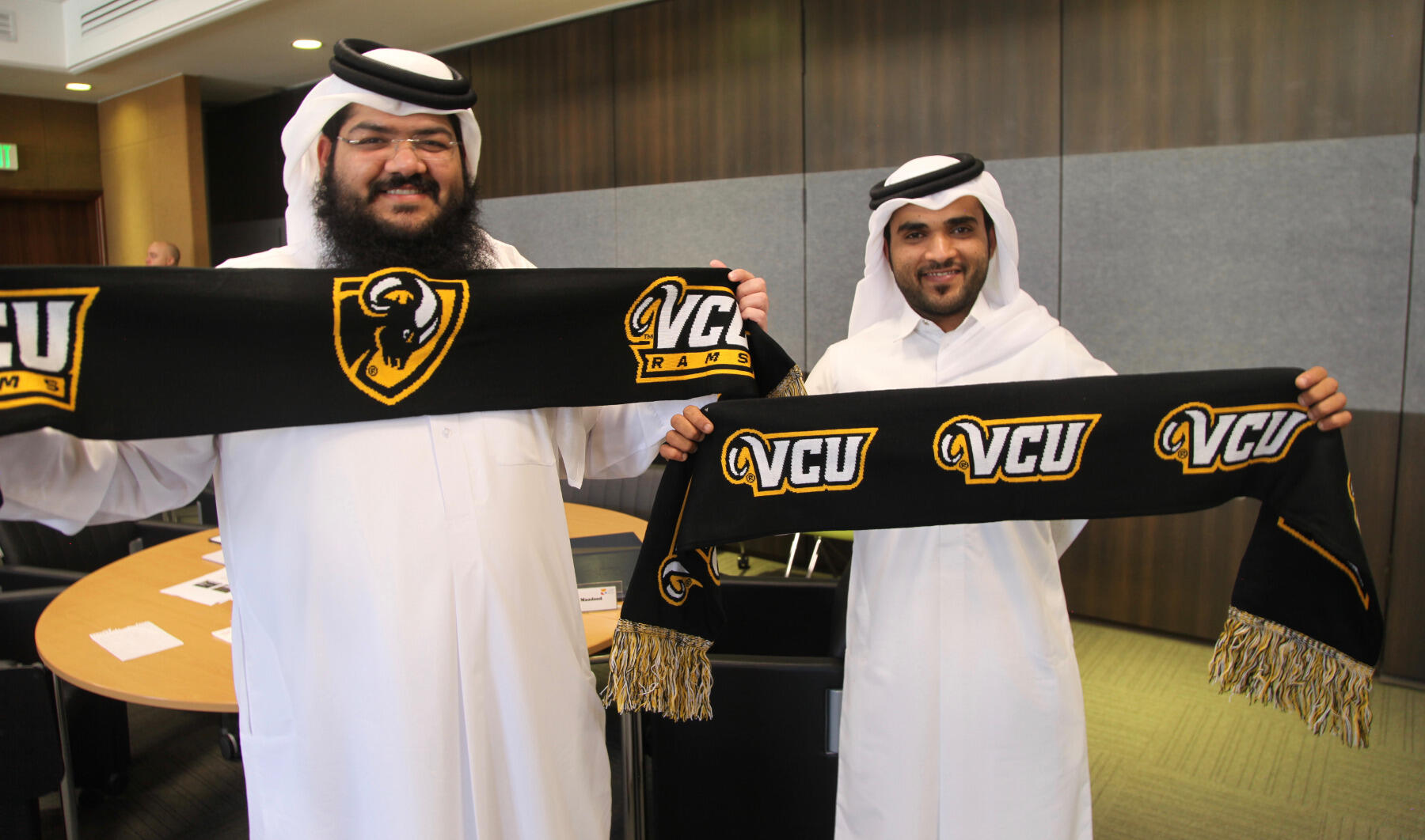 Two members of the Qatar Olympic Committee show off their VCU scarves, which were gifts from the Center for Sport Leadership upon completion of the program.