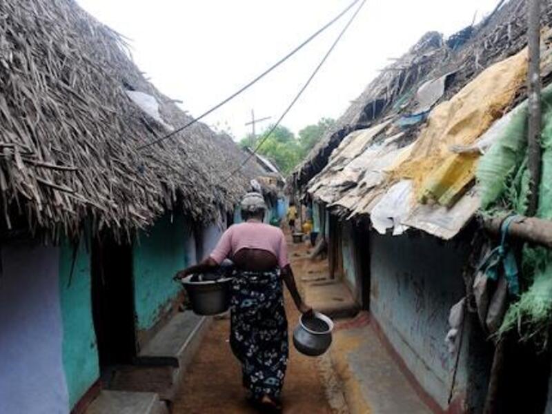 A woman walking between huts in a refugee camp. (Courtesy of Miriam Kuttikat)