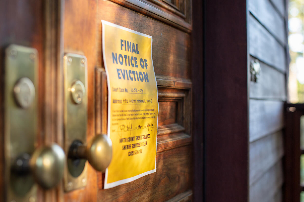 An eviction notice posted on the door of a building.