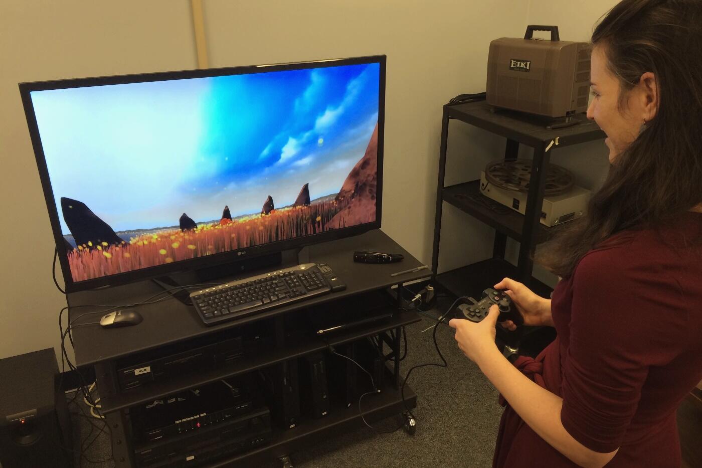 Emily Davis Winthrop, arts collection librarian, demonstrates playing "Flower" on a PlayStation 3 in VCU Libraries' video game room. 