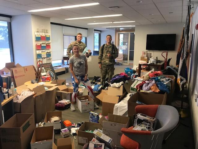 student veterans standing in a room with boxes of donations