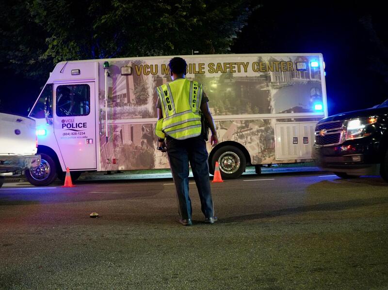 A police officer stands in front of a police van.