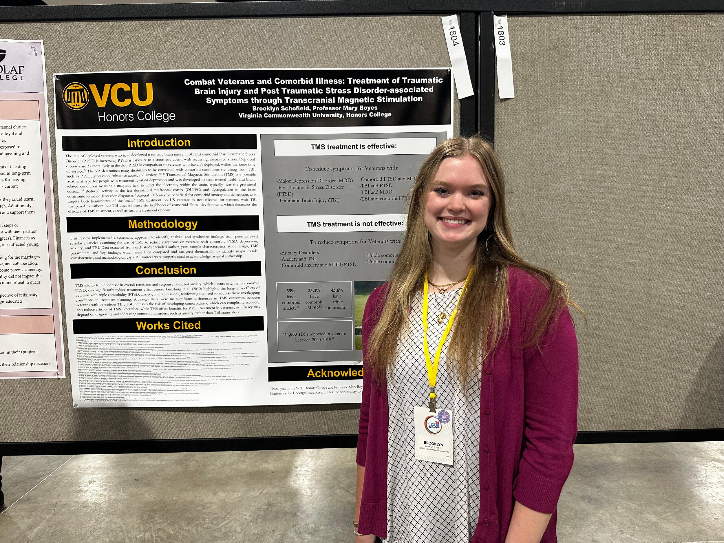 A woman stands in front of a research poster board.