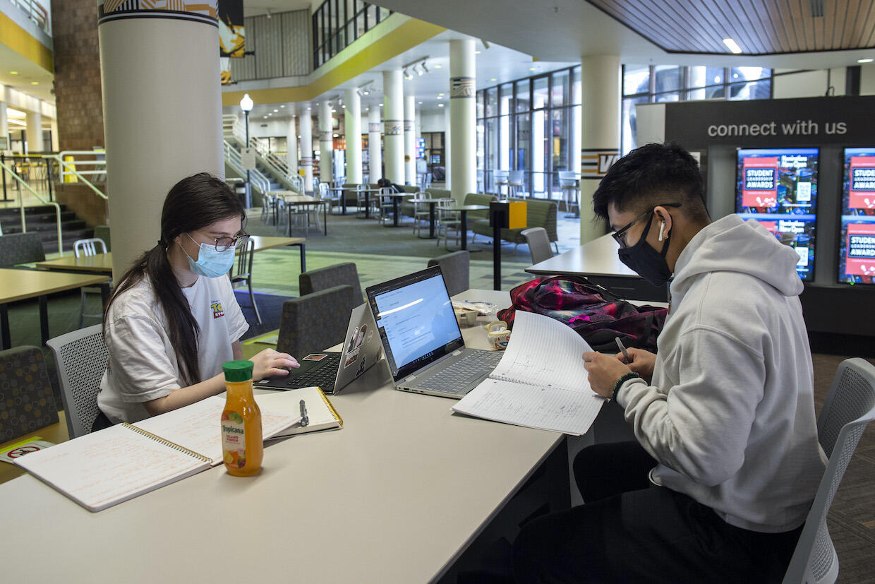 Two students studying inside the Student Commons building.