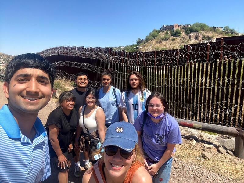 Anita Nadal (in black with her hands on her knees) and the seven students that travelled with her to Nogales, Arizona at the border wall.