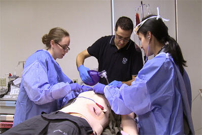 With stethoscope in hand, VCU’s OCPR science-medical writer, Sathya Achia Abraham monitors the breathing of a patient during a simulation demonstration led by Cathy Grossman, M.D., assistant professor in the Division of Pulmonary and Critical Care, and Rabih Halabi, M.D., with the Department of Internal Medicine. The demonstration took place during the Center for Human Simulation and Patient Safety open house. Image courtesy of Melissa Gordon.