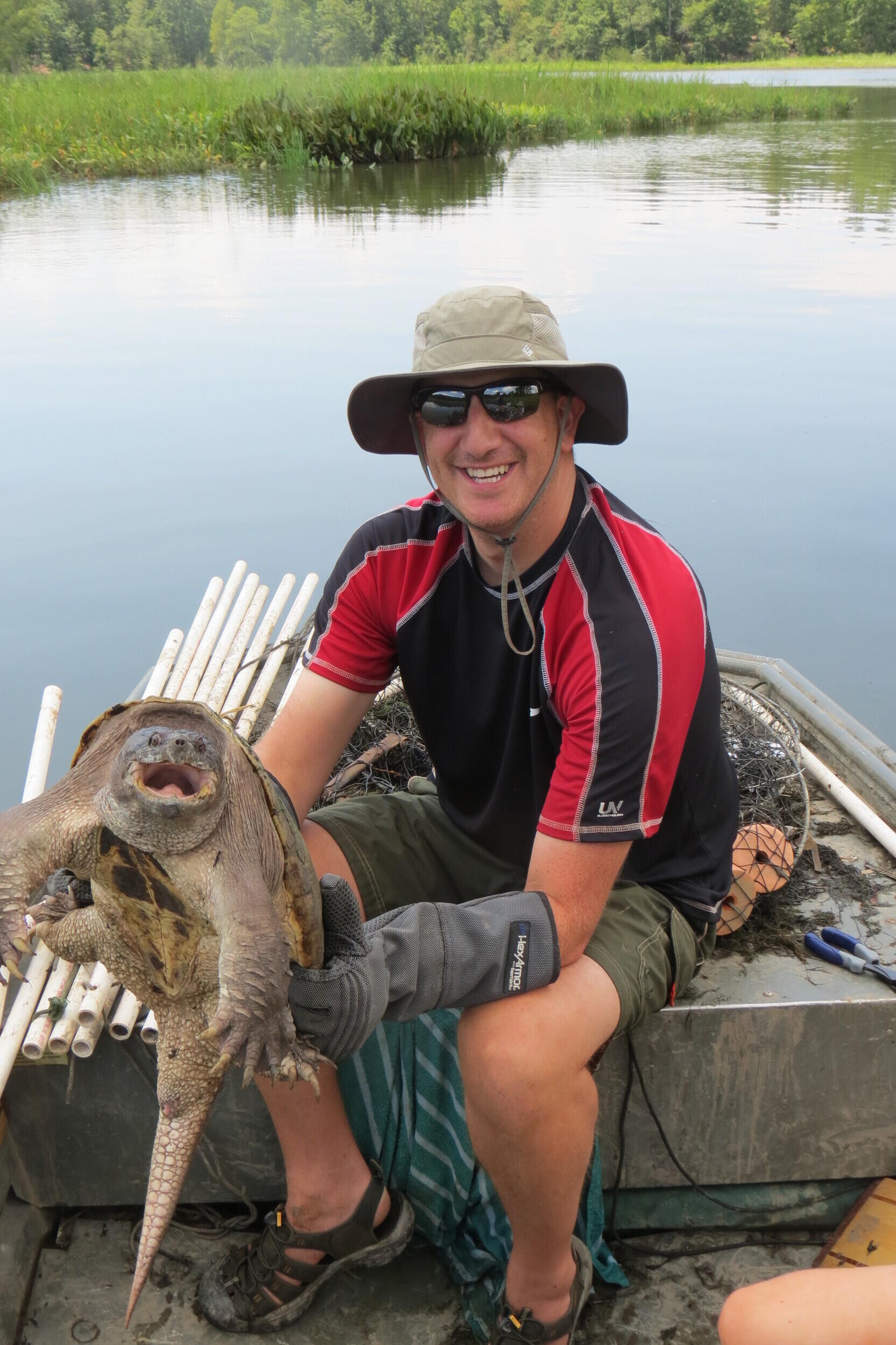 Armed with gauntlets, or protective gloves, Colteaux holds a snapping turtle. (Photo credit: Courtesy of Team Snapper)