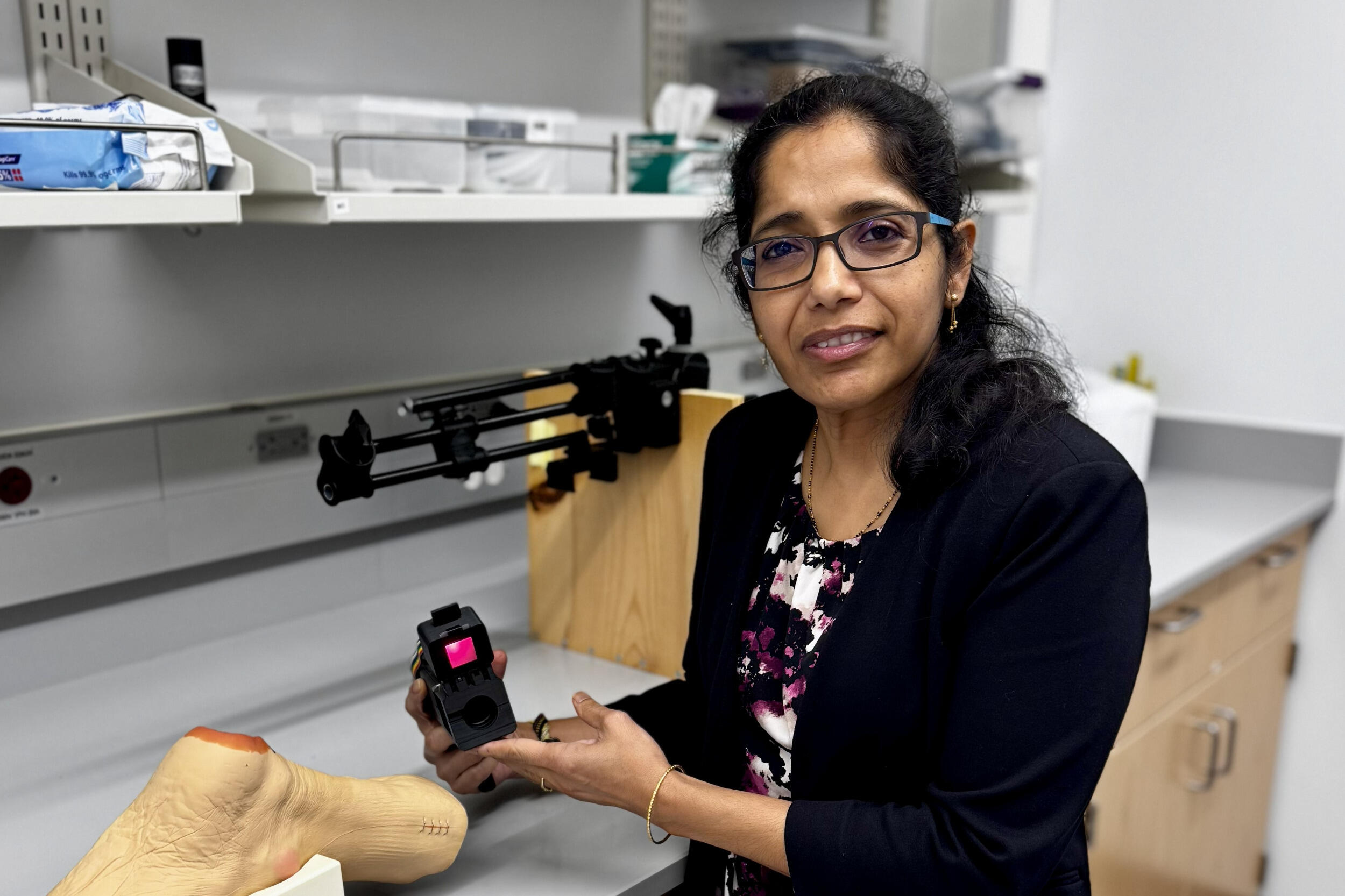 A woman holds a scanner in her hands.