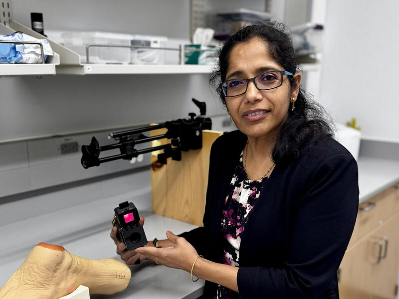 A woman holds a scanner in her hands.