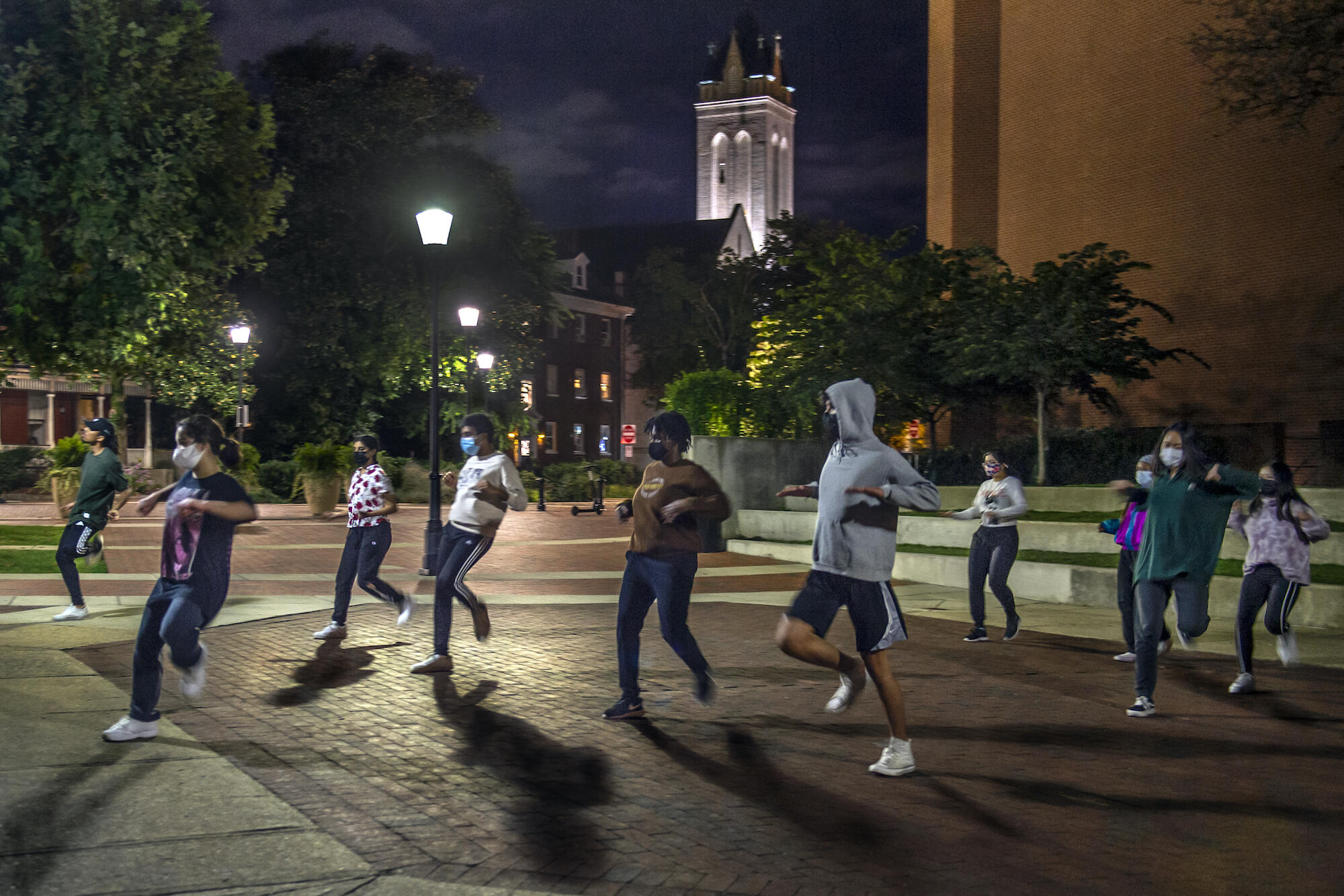 students dance outside in the dark
