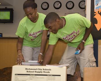 VCU Welcome Week staff members Vnai Beill and Greg Gilliam review the contents of the school supply donation box inside of the Student Commons.  Students, faculty and staff and drop off school supply donations at designated sites across the university.  Photo by Melissa Gordon, Office of University Communications and Public Relations.