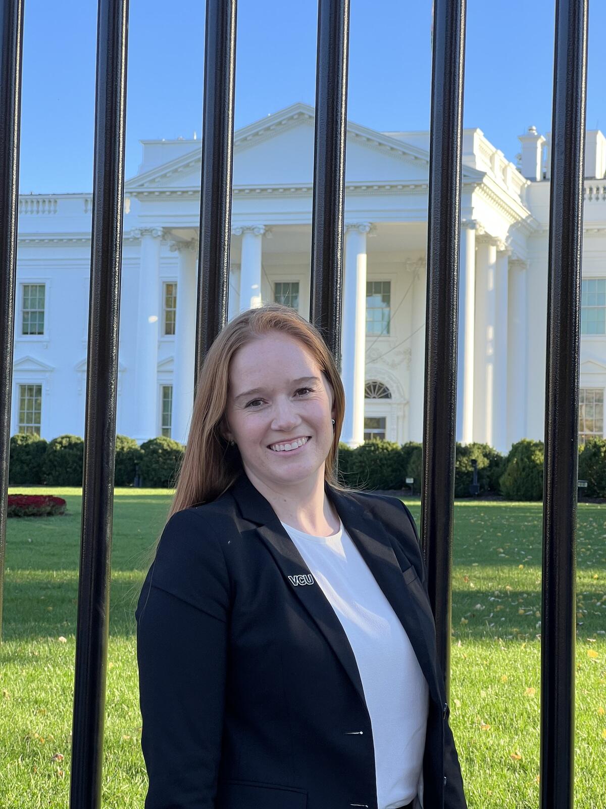 Anne Skelton smiles with the White House in the background behind her.