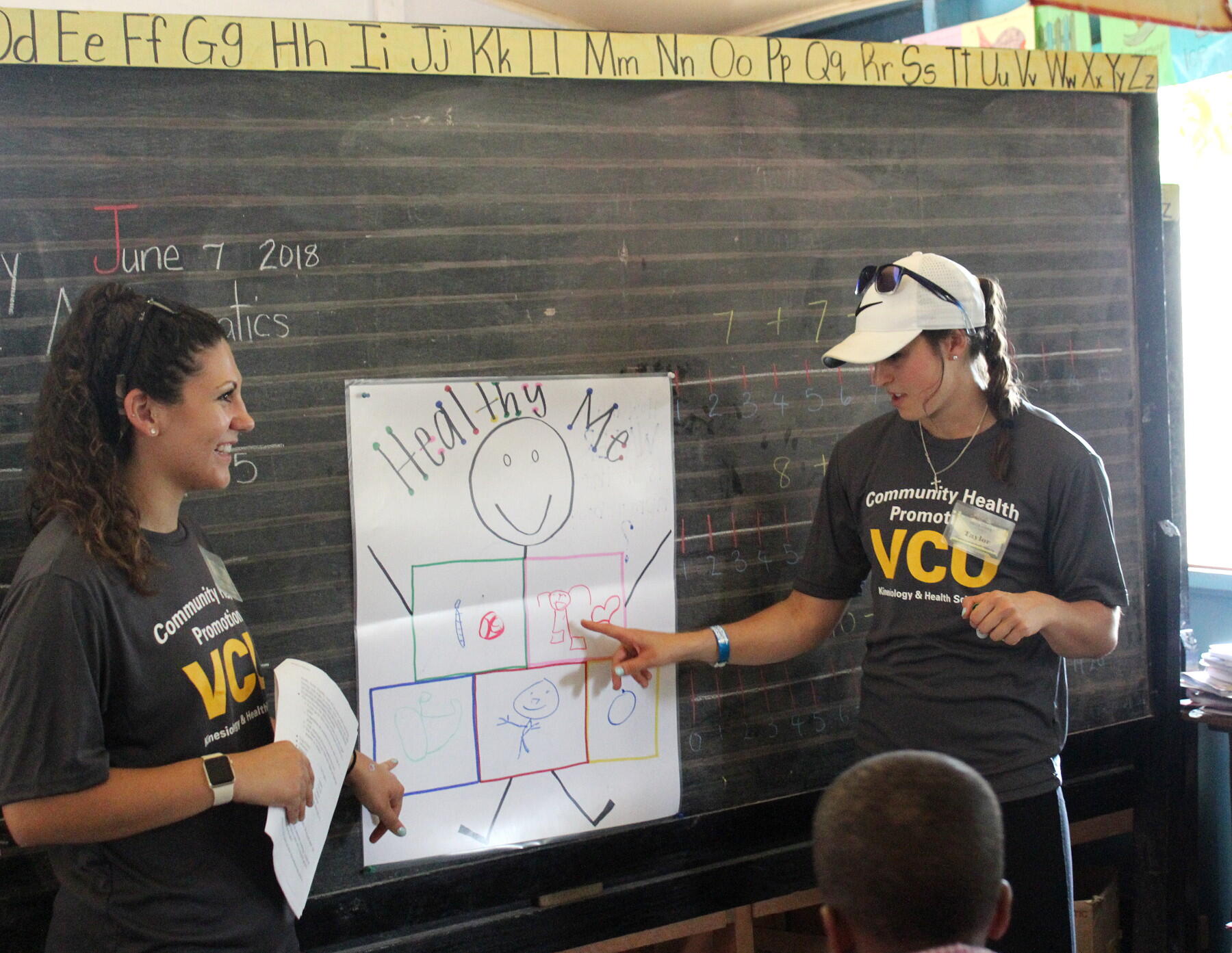Left to right: VCU students Katharine Mikayla Attanasio and Taylor Vittaletti conduct an interactive healthy nutrition lesson at a primary school. (Courtesy photo)