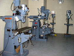 Vertical milling machines and drill presses from Philip Morris await installation in the School of Engineering's High Bay lab.