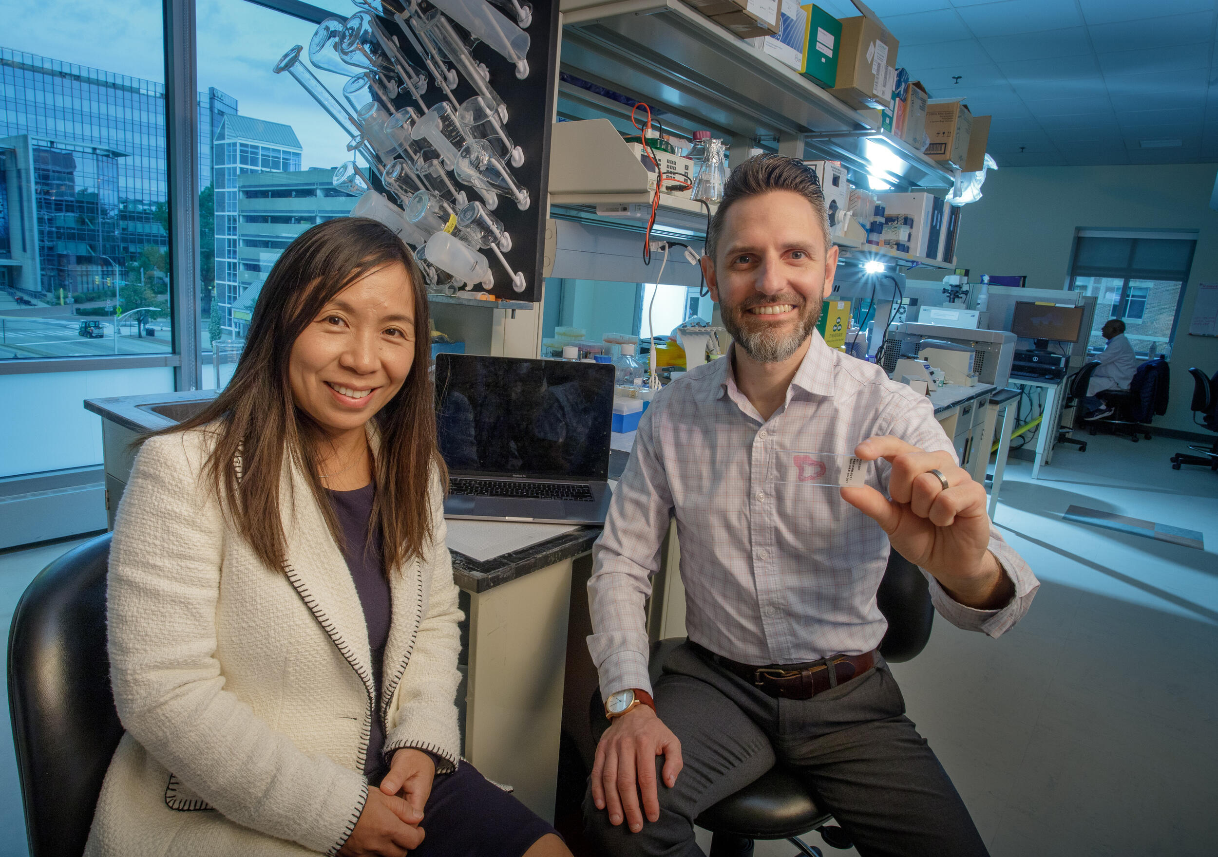 A man in a woman sit in a lab environment.