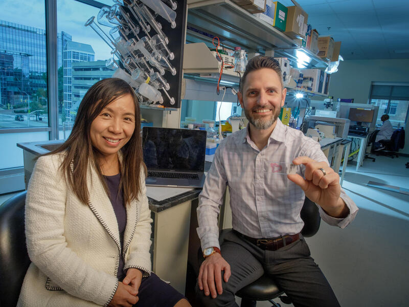 A man in a woman sit in a lab environment.
