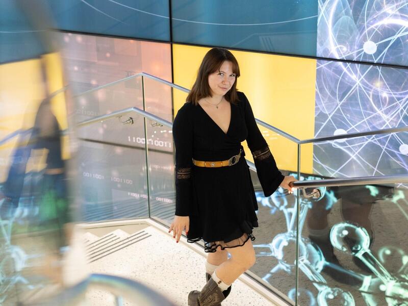 A photo of a woman standing on a staircase. 