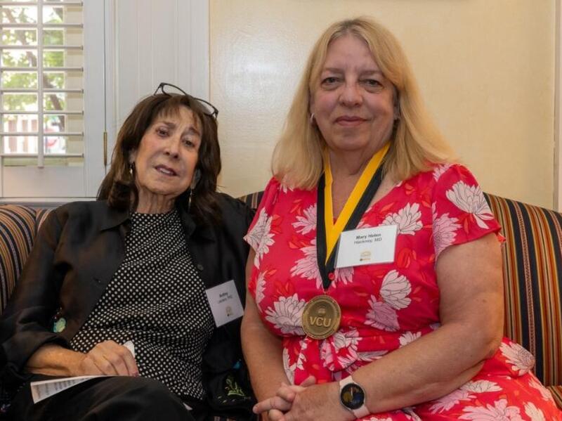 A photo of two women sitting on a couch. 