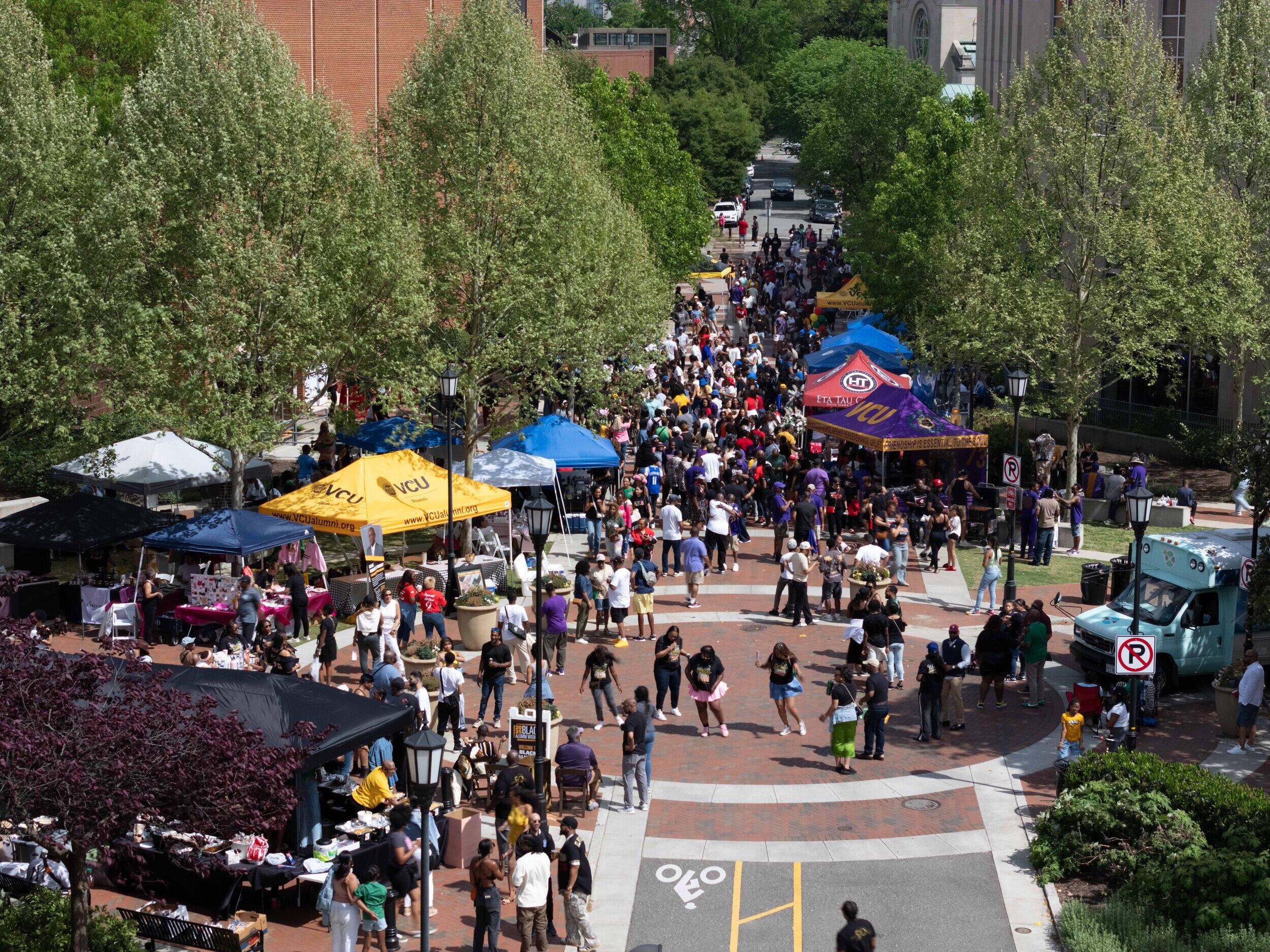 A photo of a large crowd of people milling about tents. 