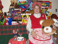 Surrounded by new toys, Karen Monger, billing manager for PM & R, looks very comfortable in the role of Mrs. Claus. Monger chairs the department's holiday toy drive committee.

Photo by Michael Ford, University News Services