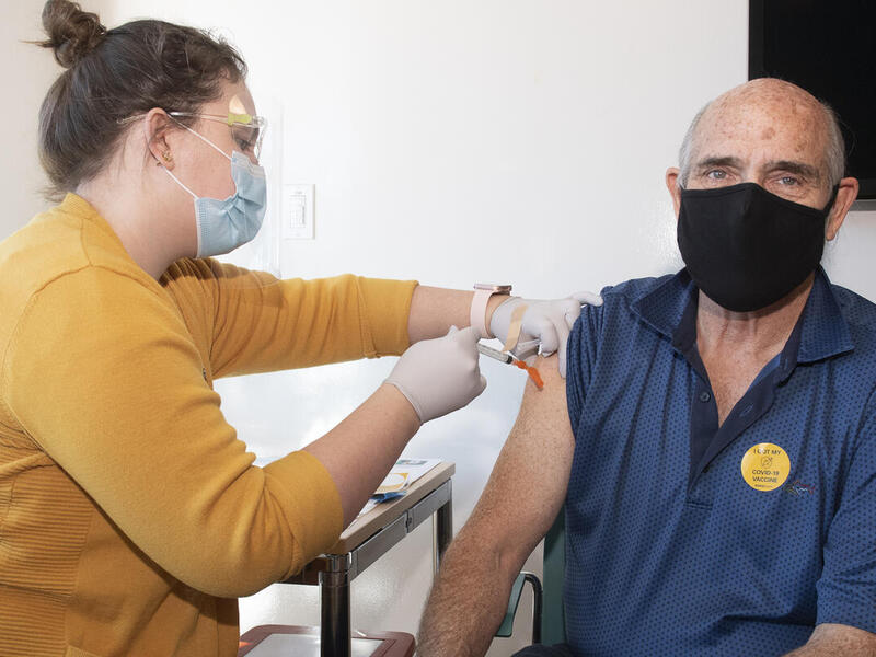 VCU School of Nursing student Jennifer Bucknam vaccinates community member Norman Gold. Bucknam is one of many students at VCU stepping up to administer COVID-19 vaccine shots to fill a statewide need. (Tom Kojcsich, University Relations)