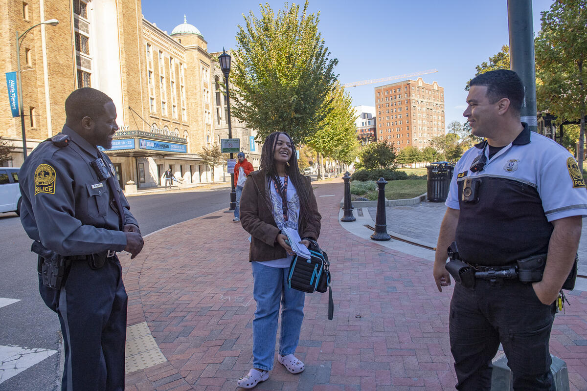 Two police officers speaking with a woman who is standing in between them 