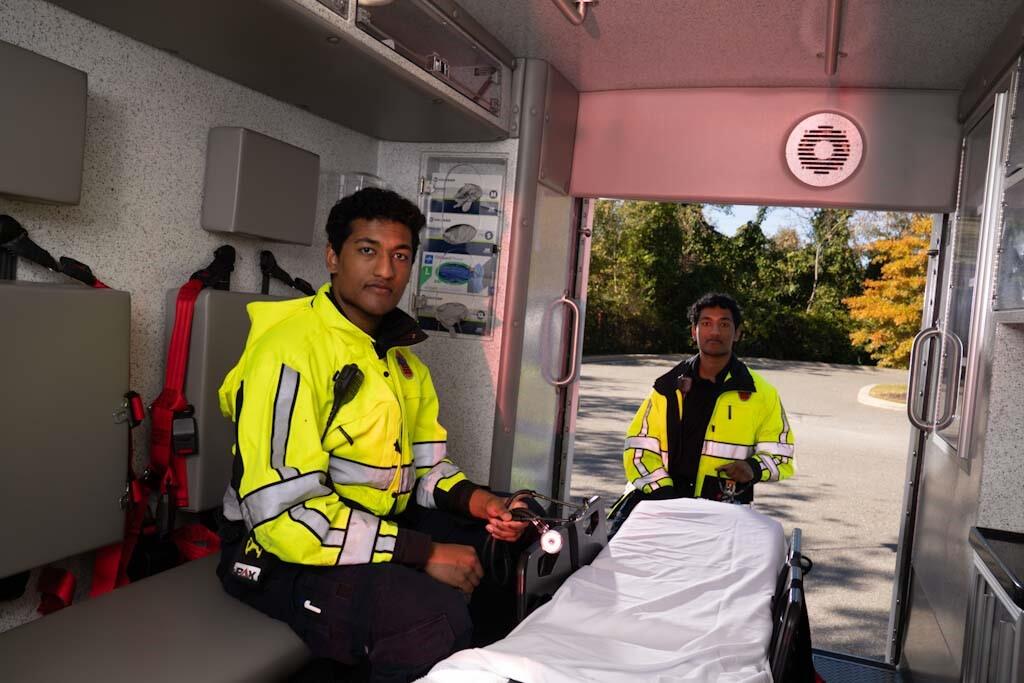 A photo of two men in the back of an ambluance 