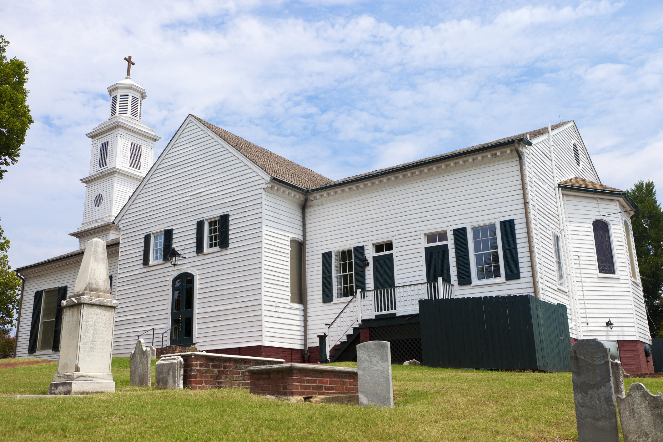 A photo of a church with a small graveyard in front of it. 