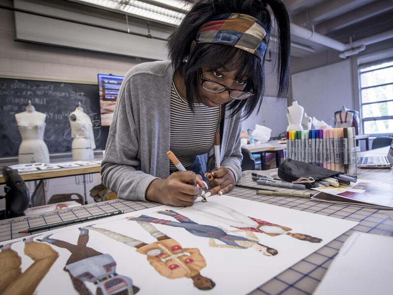 young Black woman working in a fashion design classroom at V C U
