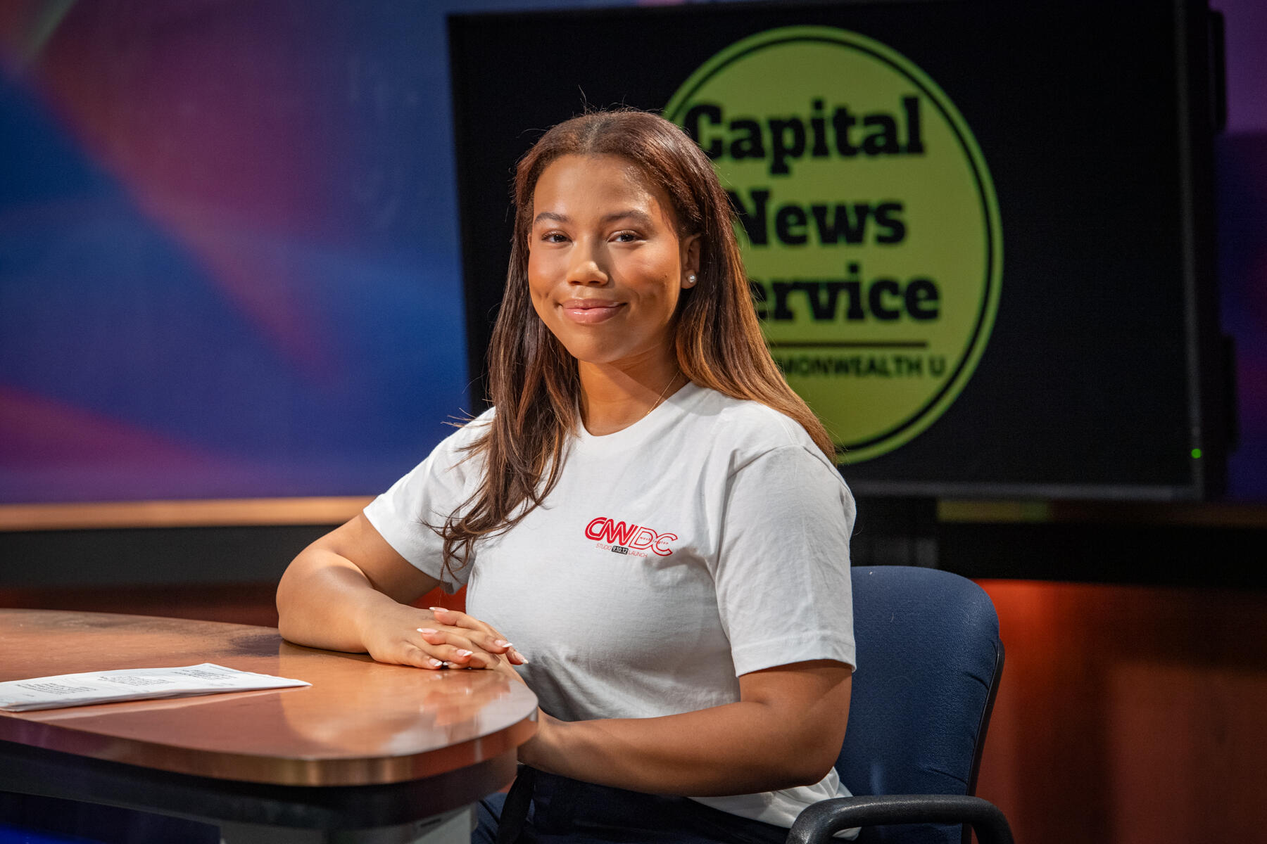 A photo of a woman sitting at a desk.